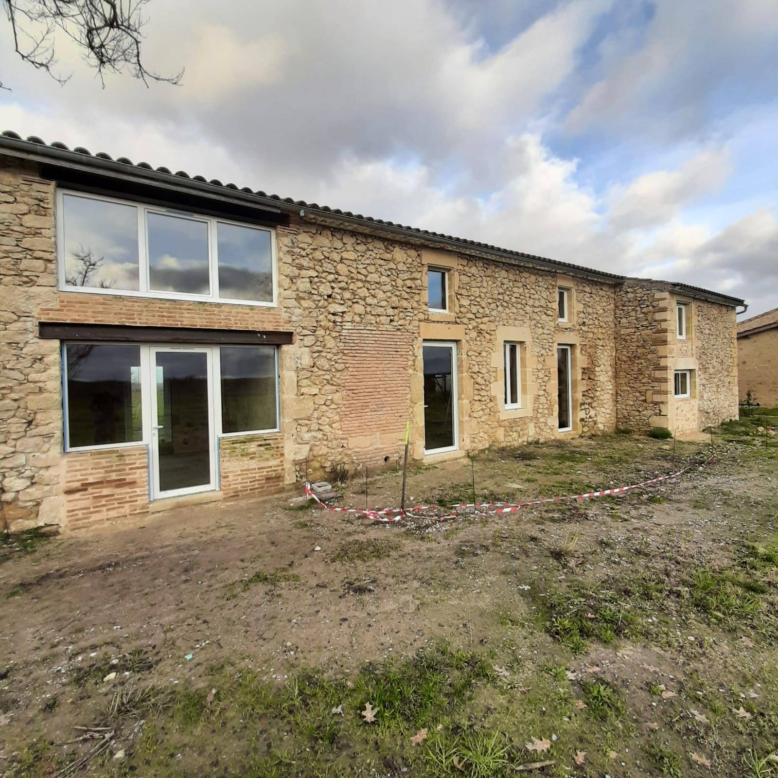 Rénovation d'une maison en pierre située à Saint Pierre de Mons avec des menuiseries pvc schucco et des menuiseries installux en aluminium