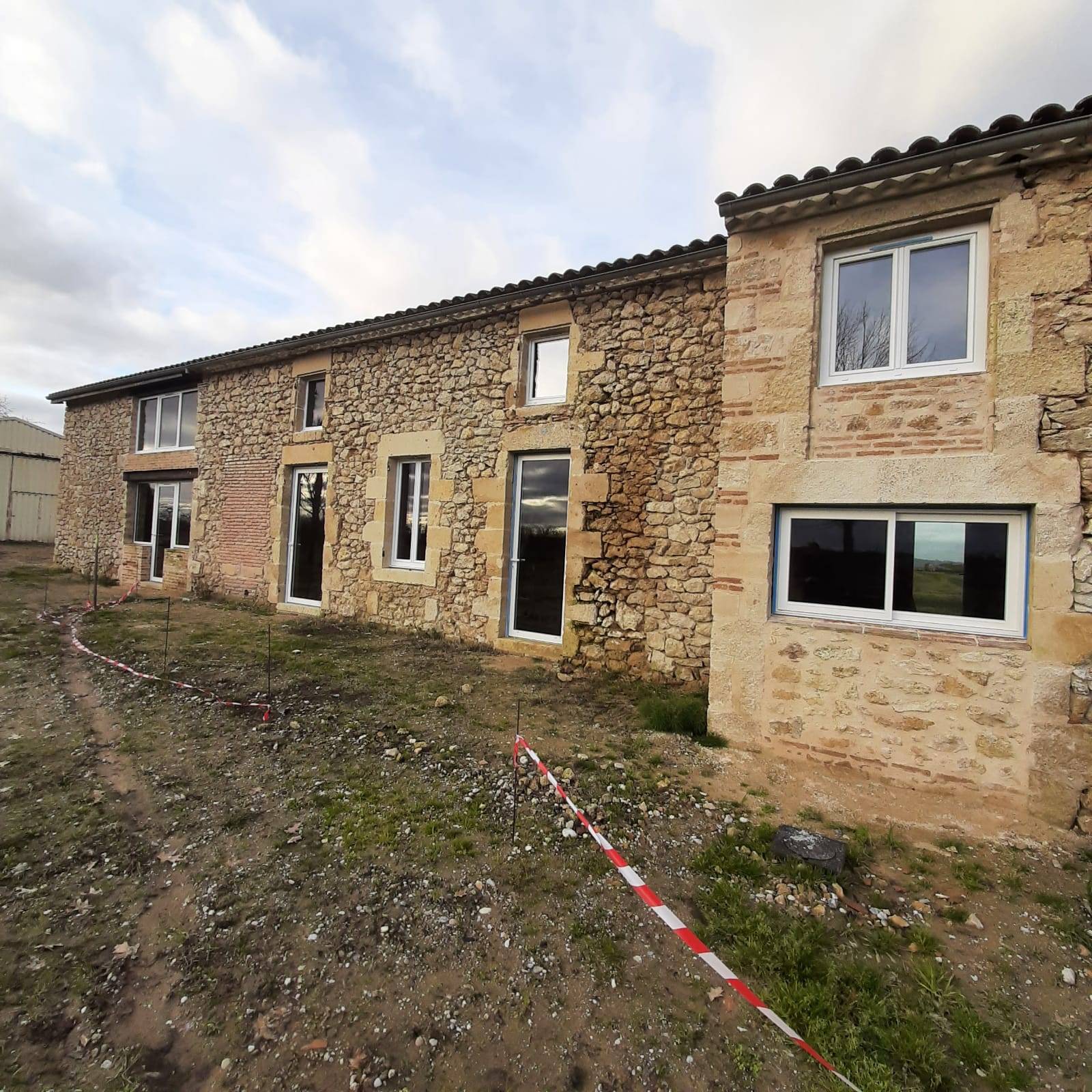 Rénovation d'une maison en pierre située à Saint Pierre de Mons avec des menuiseries pvc schucco et des menuiseries installux en aluminium