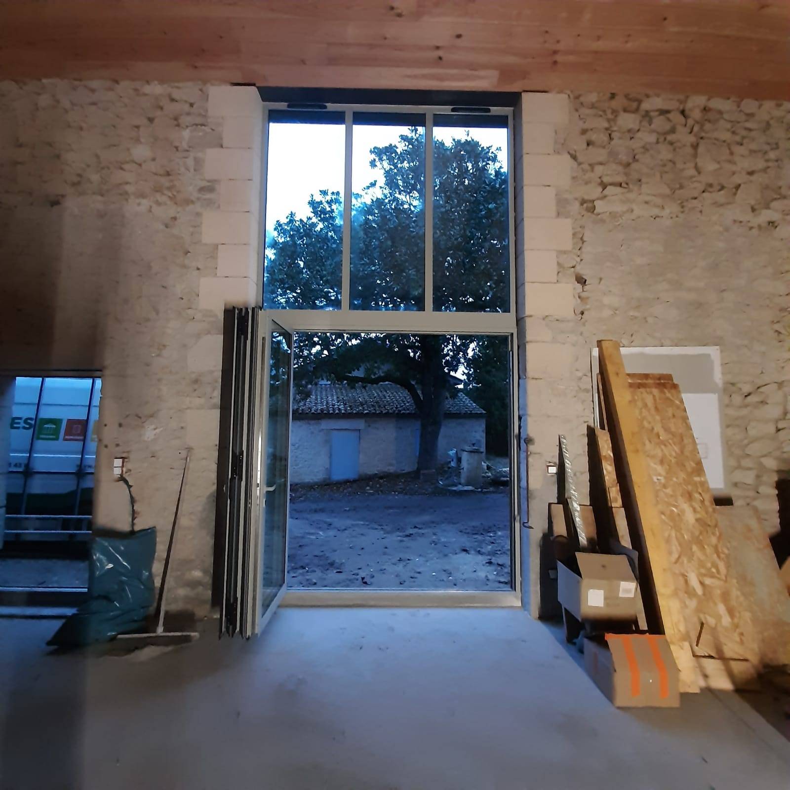 Menuiserie grande ouverture qui allie aluminium et pierre 