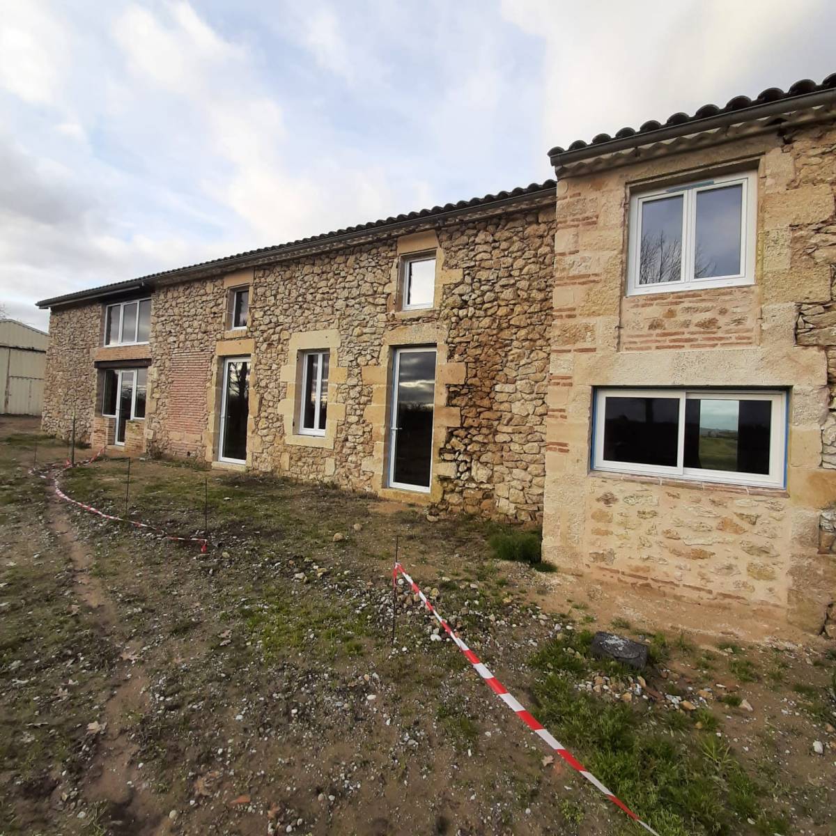 Rénovation d'une maison en pierre située à Saint Pierre de Mons avec des menuiseries pvc schucco et des menuiseries installux en aluminium